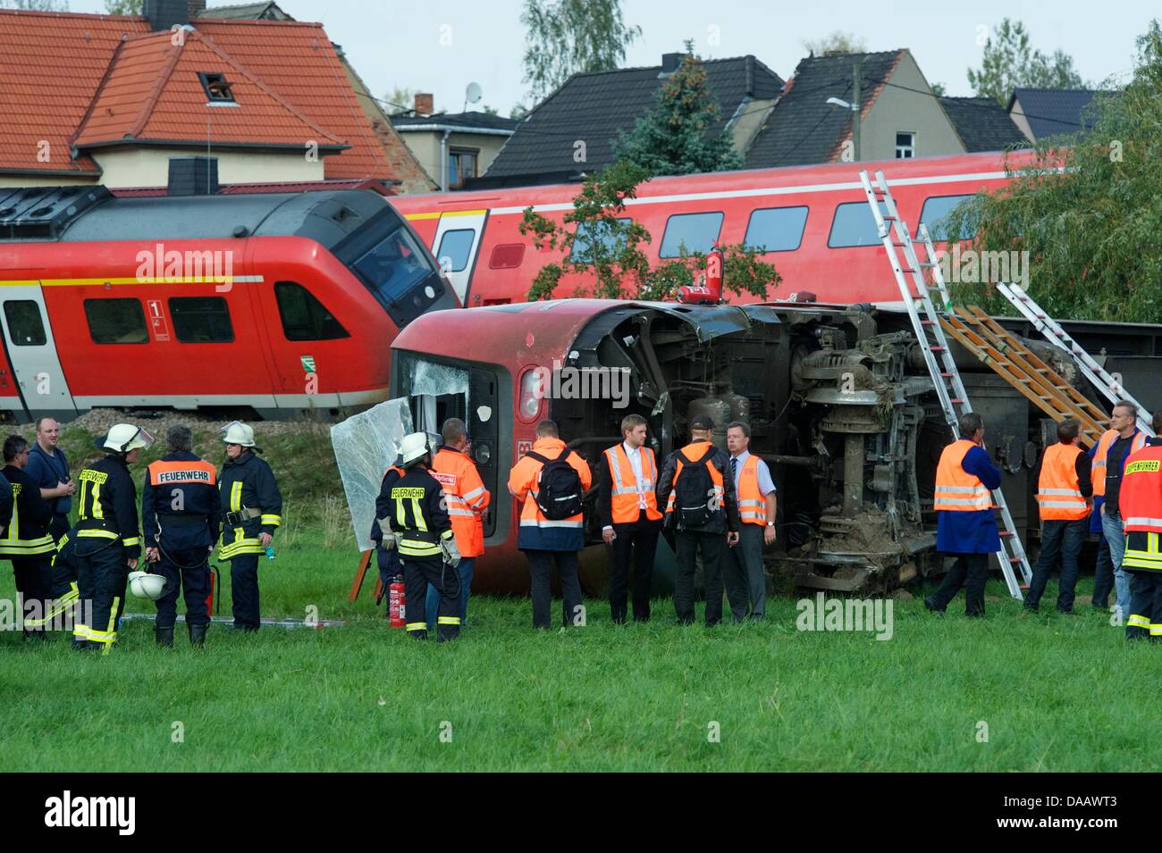 Les équipes de sauvetage se tenir à côté d'un demlished après un accident de train à Lauterbach, Allemagne, 20 septembre 2011. Un regional express s'est écrasé dans une voiture autour d'une heures et les trois premières voitures à voyageurs ont déraillé. De nombreuses personnes ont été blessées au cours de l'accident. Peter Endig Banque D'Images