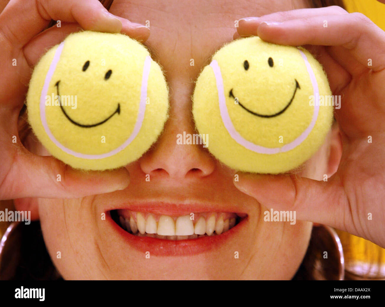 Fichier - une archive photo datée du 09 février 2006 montre Ellen de Boer couvrant ses yeux avec Smiley-balles de tennis au Salon Ambiente 2006 biens de consommation en FGrankfurt/Main, Allemagne. Selon une étude publiée mardi, 20 septembre 2011, les Allemands sont plus satisfaits aujourd'hui qu'ils ont été au cours des dix dernières années. Photo : Frank Rumpenhorst Banque D'Images