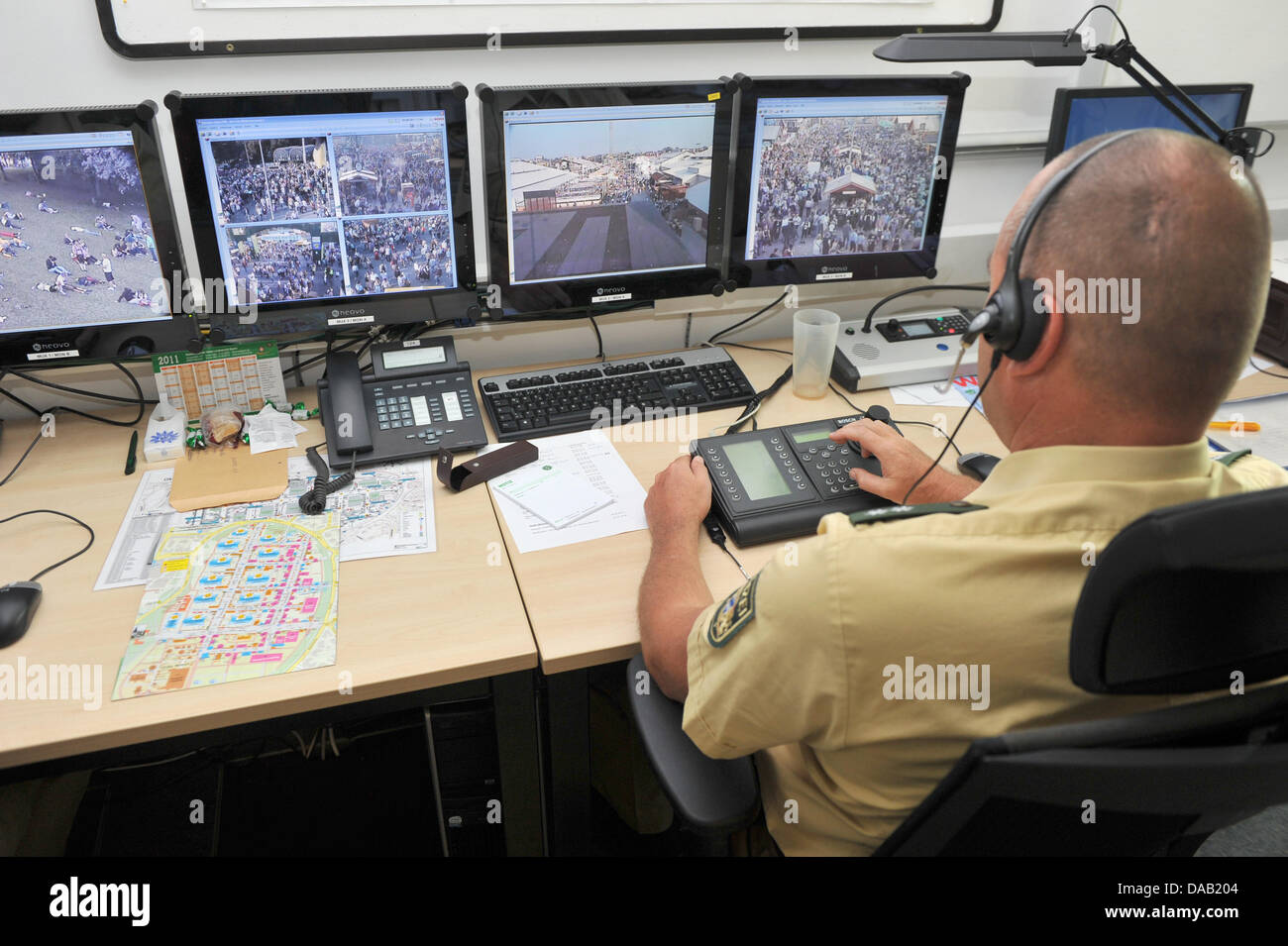 Un agent de police un ensemble d'écrans vidéo montrant des images de vidéosurveillance de l'Oktoberfest, la fête de la bière sur la Theresienwiese à Munich, Allemagne, le 23 septembre 2011. La 179e fête de la bière de Munich se poursuit jusqu'au 3 octobre 2011 et attire des visiteurs de partout dans le monde chaque année. Photo : Felix Hoerhager Banque D'Images