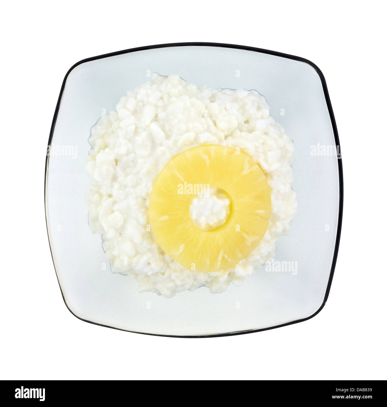 Vue de dessus d'un gris translucide bol avec une assiette de fromage cottage et une seule tranche d'ananas sur un fond blanc. Banque D'Images