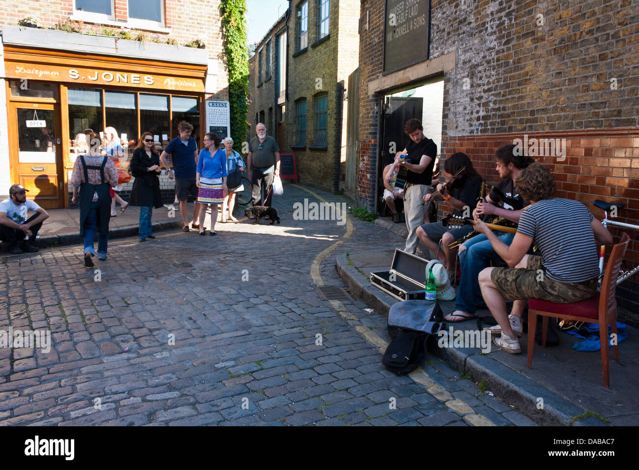 Une bande de jeunes musiciens ambulants pour effectuer dans les rues de Londres à Columbia Road Flower Market, London, England, GB, au Royaume-Uni. Banque D'Images