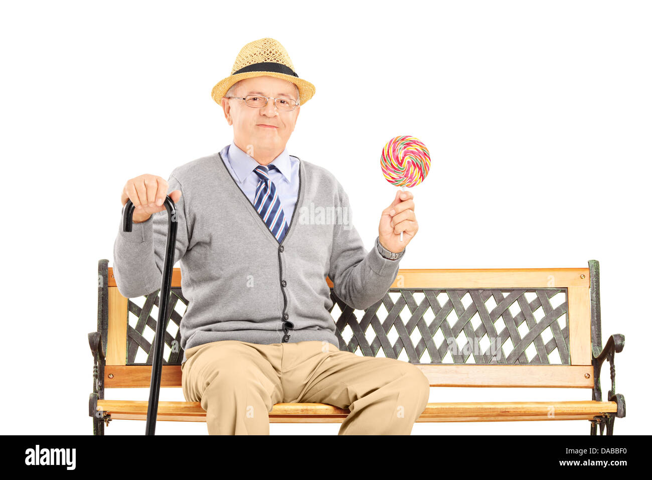 Représentant Senior assis sur un banc en bois et tenant une sucette colorée Banque D'Images