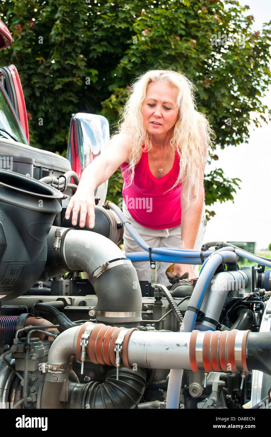 Femme adulte conducteur du camion faisant une inspection pré-trajet sur son chariot avant son terme. Banque D'Images