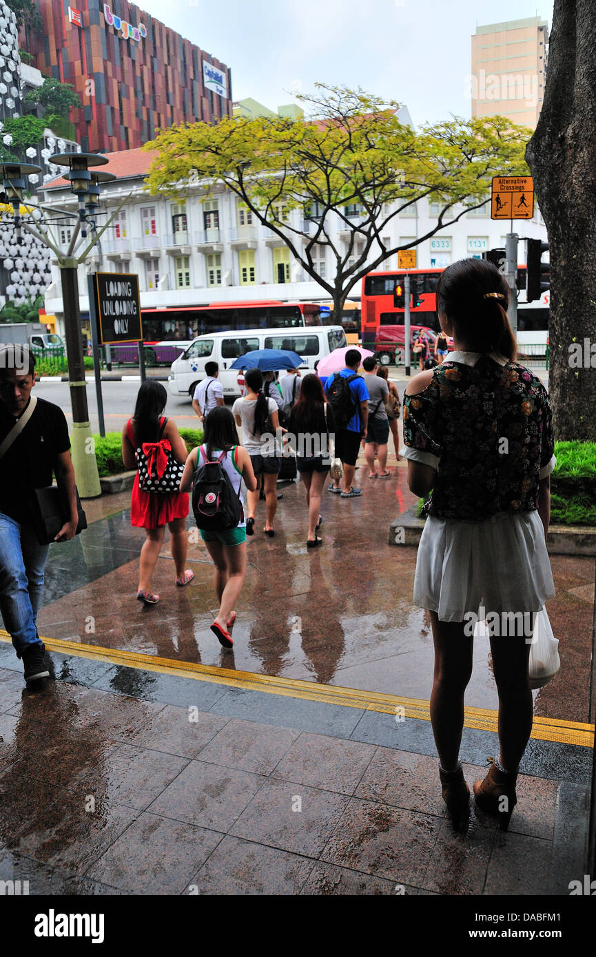 Jeune fille en attente de Cross Road à Singapour Marché Bugis Street Banque D'Images