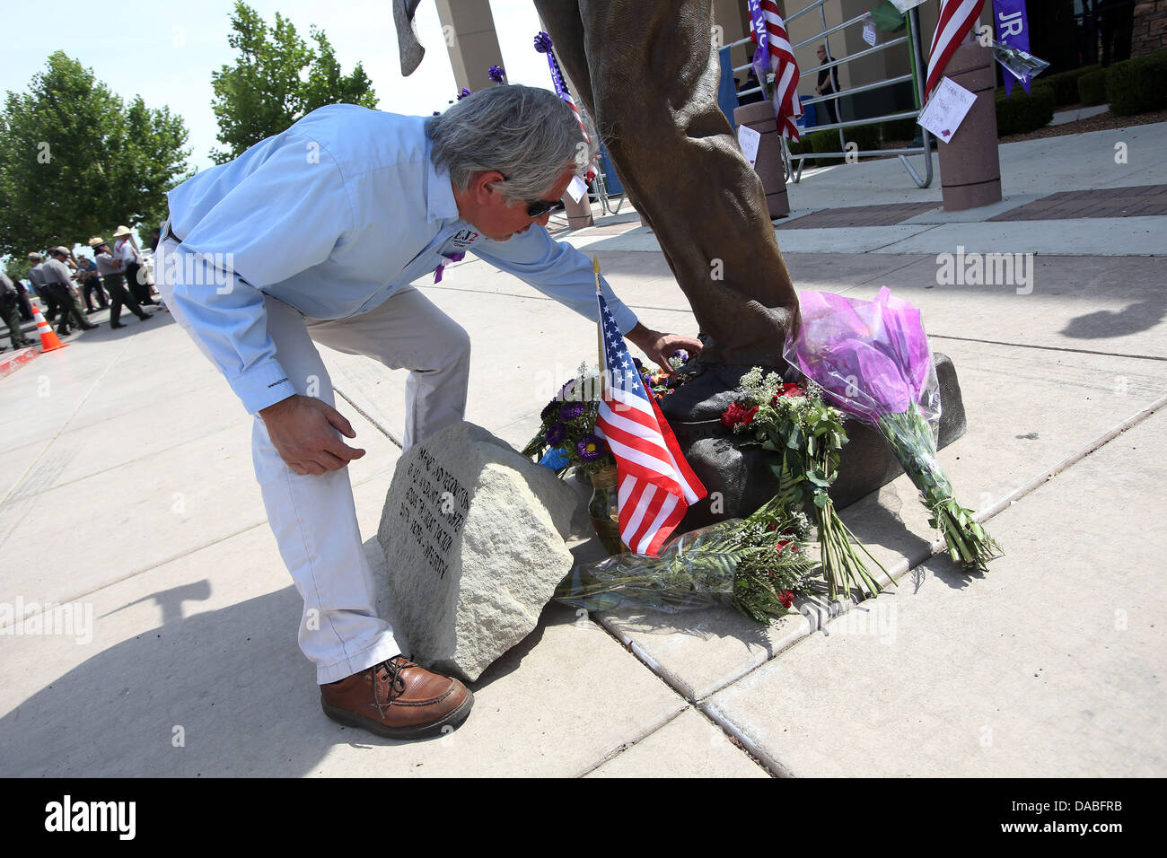 Prescott Valley, AZ, États-Unis d'Amérique. 09 juillet 2013. John Echeverri met une relique à la base d'un pompier à l'extérieur du mémorial statue Tim's Toyota Center à Prescott, en Arizona. 19 La montagne de granit Frutopia tués dans l'incendie ont été honorés comme Yarnell un groupe mardi à un mémorial à Prescott Valley. Les pompiers de partout en Amérique du Nord a rejoint les membres de la famille et les membres de la communauté pour rendre un dernier hommage. Credit : Krista chenil/ZUMAPRESS.com/Alamy Live News Banque D'Images