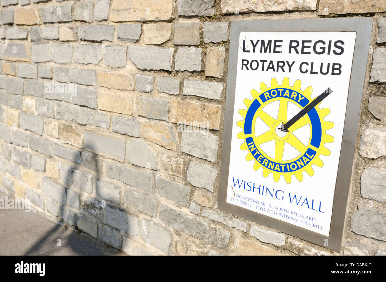 Boîte de collecte de charité mur souhaitant Rotary International Lyme Regis Banque D'Images