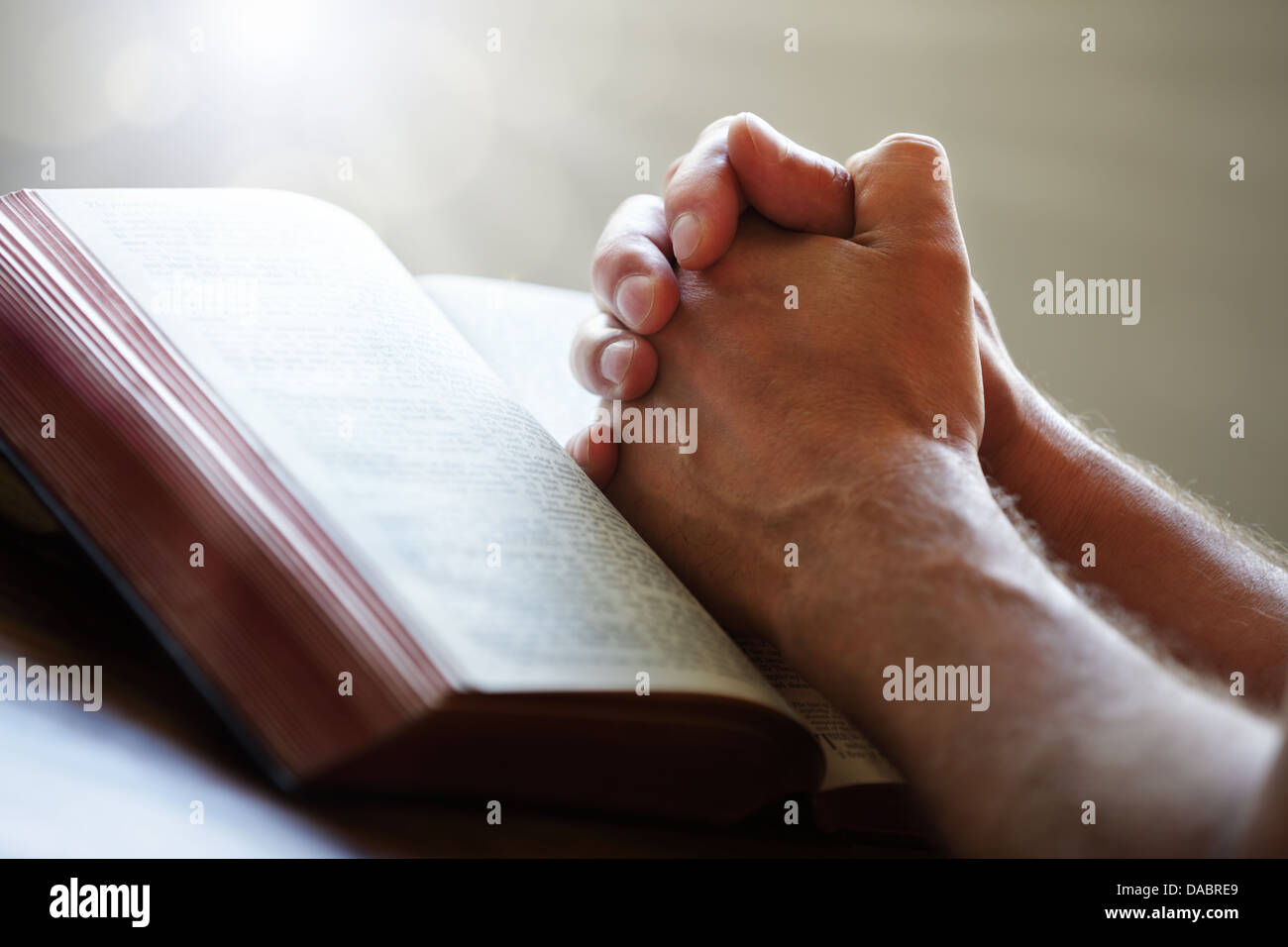 Priant les mains à une Sainte Bible Banque D'Images