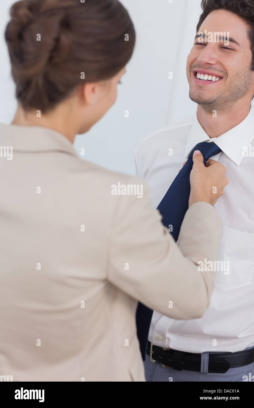 Femme aider son mari souriant de lier sa cravate Banque D'Images