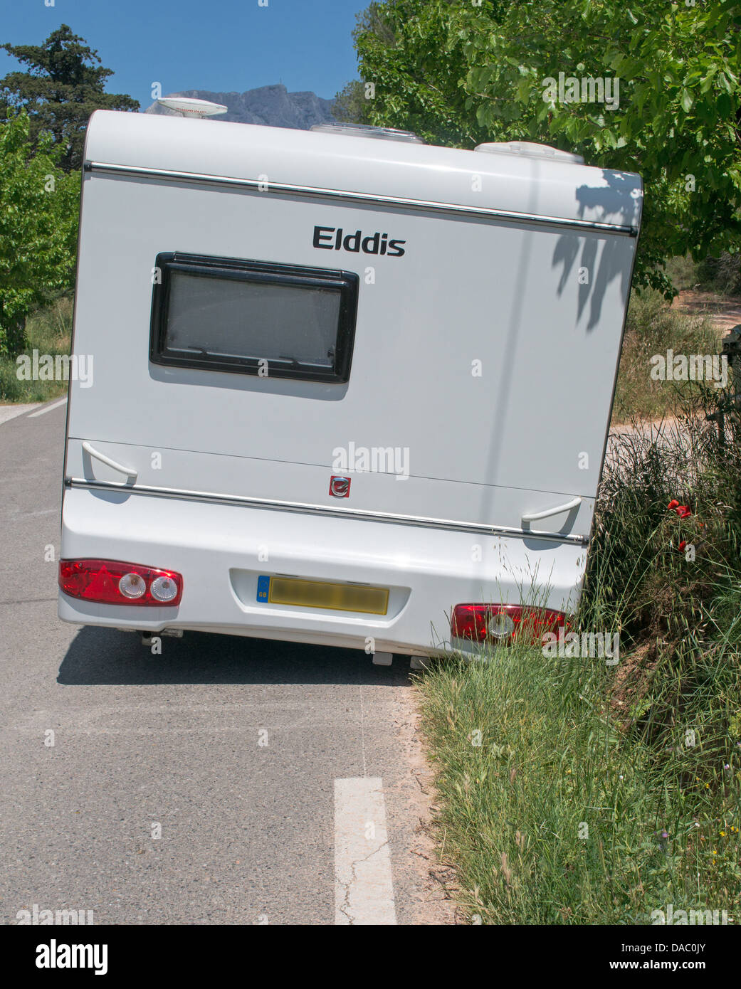 Caravane avec une roue bloquée dans un fossé en tournée en France Banque D'Images