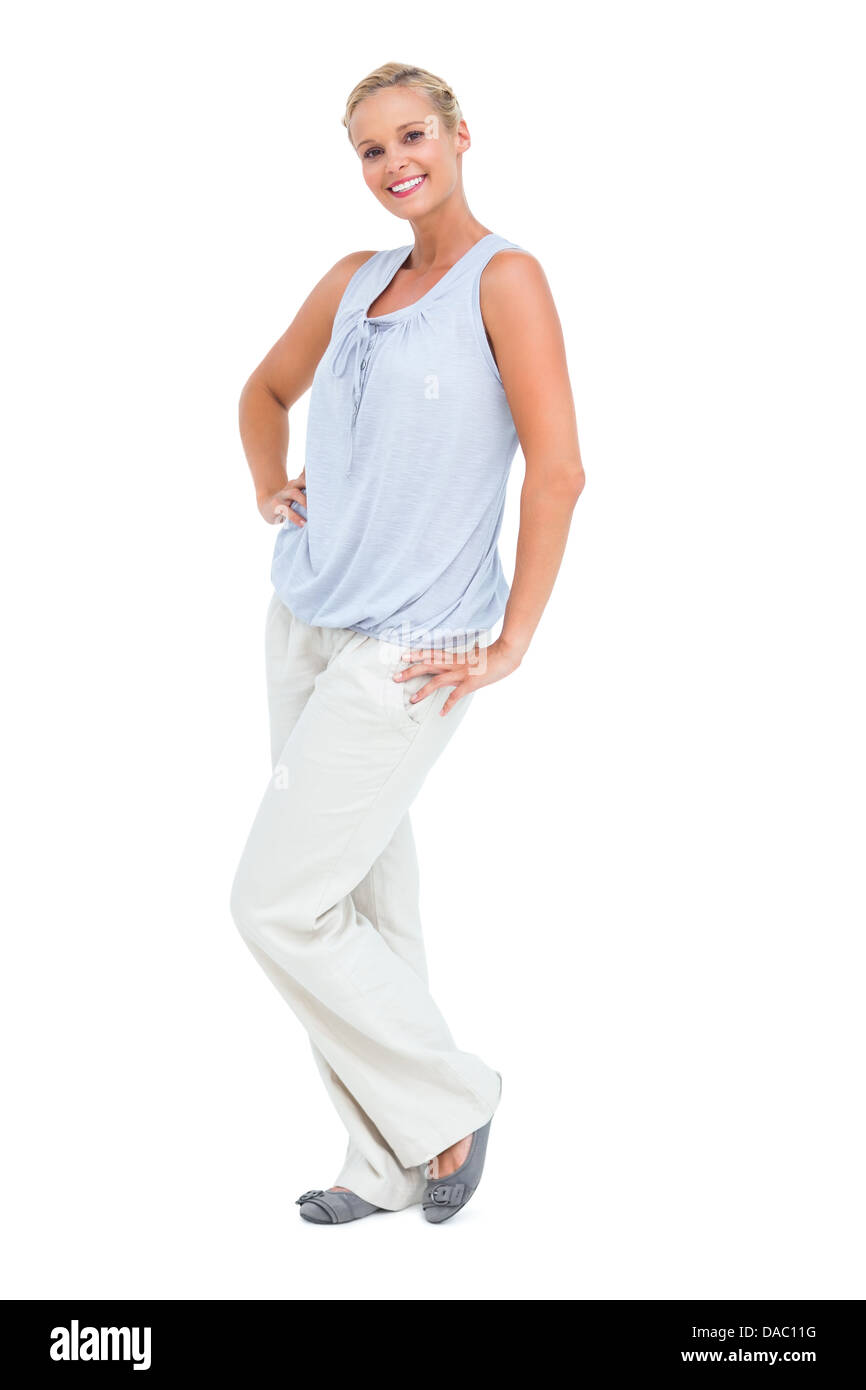 Blonde standing avec ses mains sur ses hanches smiling at camera Banque D'Images