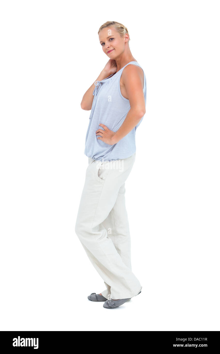 Blonde woman smiling at camera with hands on hips Banque D'Images