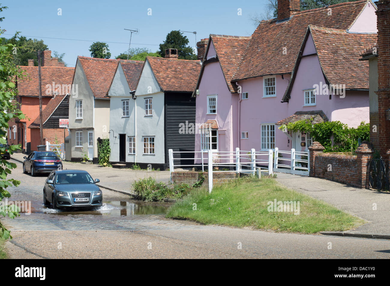 Une voiture roulant dans le Splash, le ford passant par son centre de Kersey, un village pittoresque dans le Suffolk, Angleterre. Banque D'Images