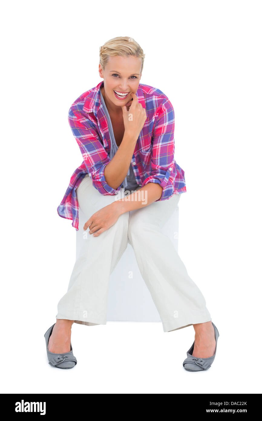 Attractive young woman sitting and smiling at camera Banque D'Images