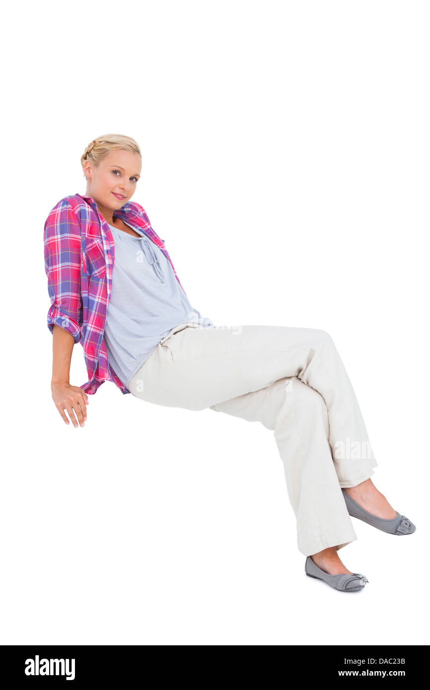 Smiling young woman sitting and looking at camera Banque D'Images