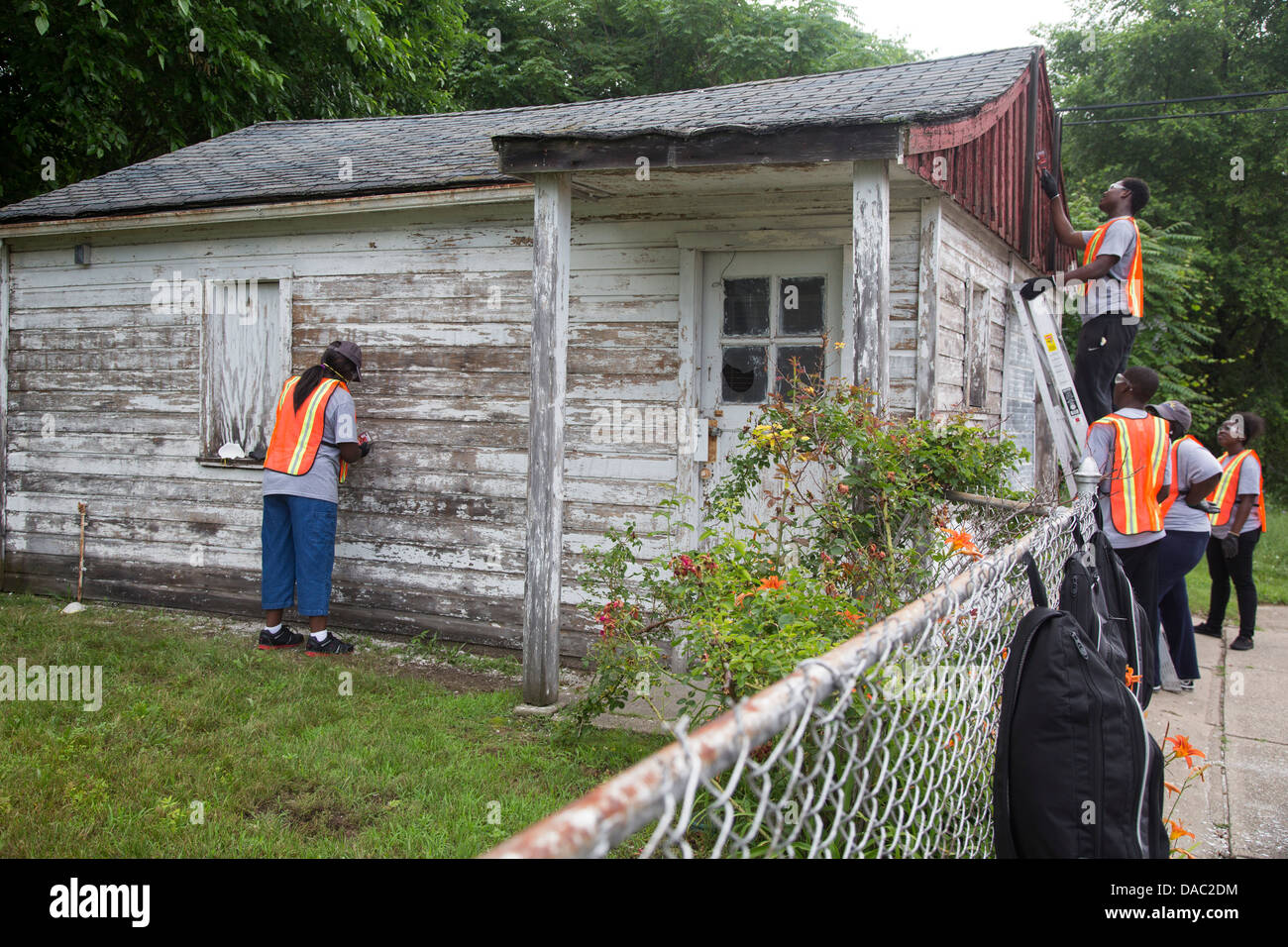 Les élèves du secondaire repeindre garage pour personne âgée à Detroit Banque D'Images