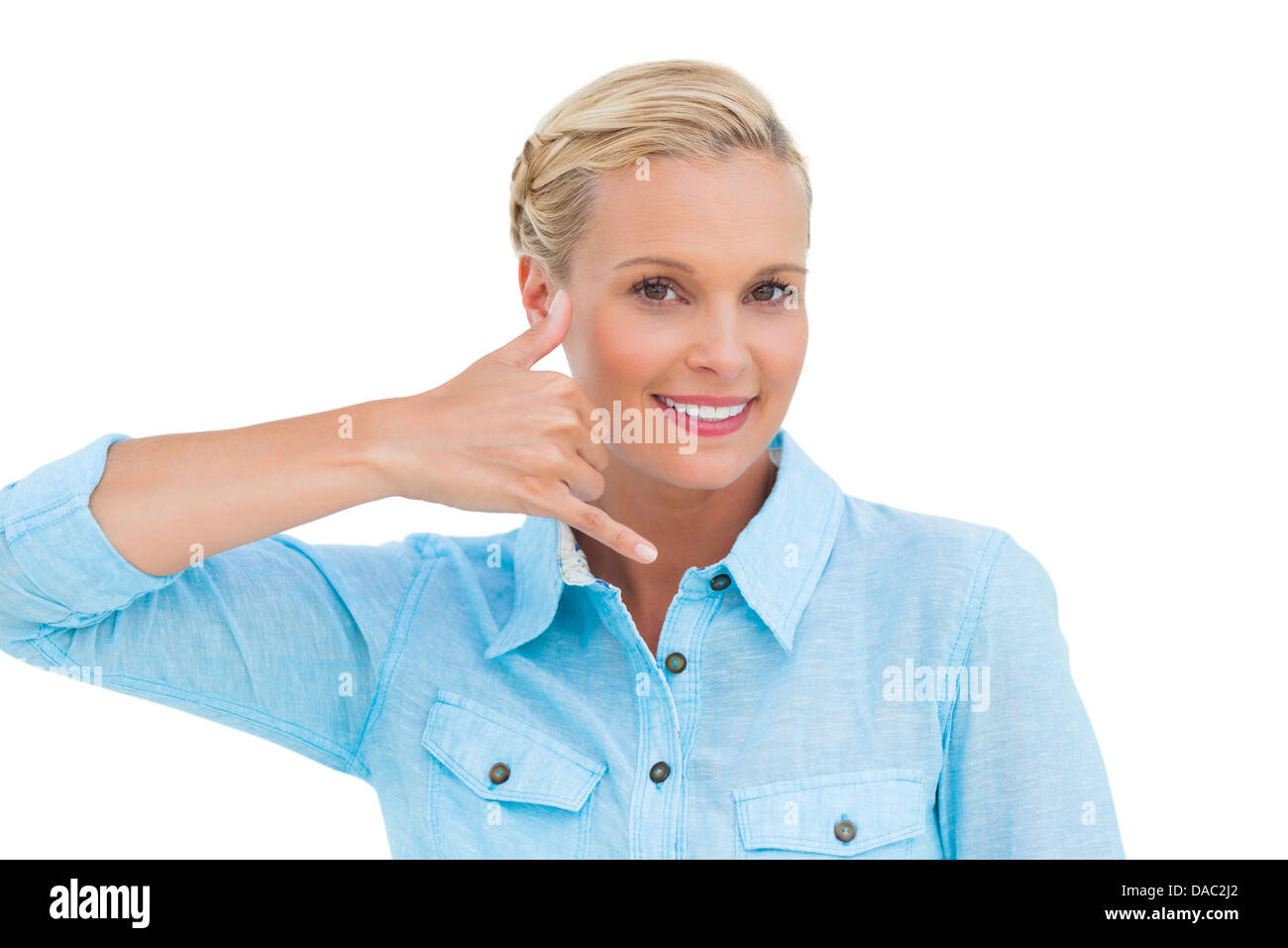 Smiling blonde à la caméra et à faire un symbole de téléphone avec sa main Banque D'Images