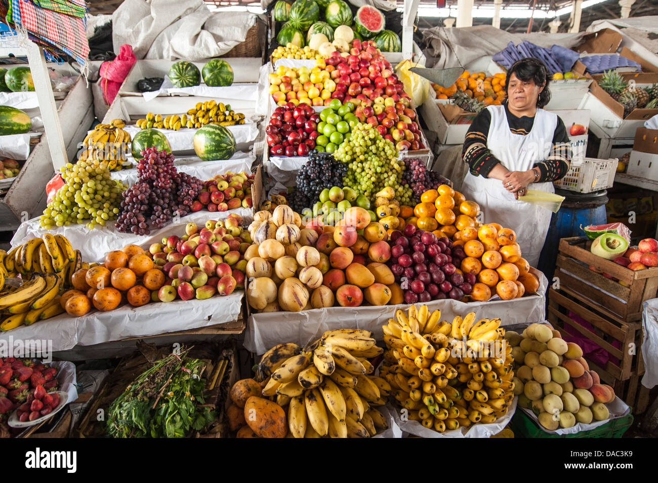 Les vendeurs de légumes fruits femme Inca boutique blocage tendant la vente au marché local au centre-ville de Cusco, Pérou. Banque D'Images