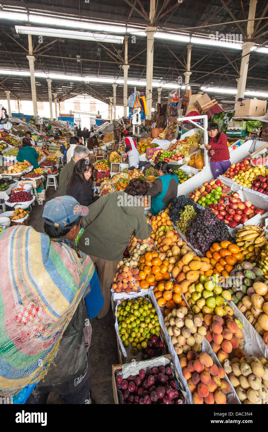 Les vendeurs de légumes fruits femmes Inca boutique de décrochage qui tend à servir les clients de vente sur le marché local au centre-ville de Cusco, Pérou. Banque D'Images
