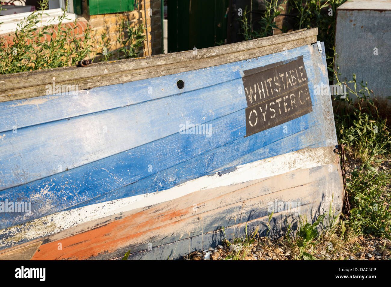 Bateau avec Whitstable Oyster sign, bleu et rouge vieux bateau en premier plan Banque D'Images