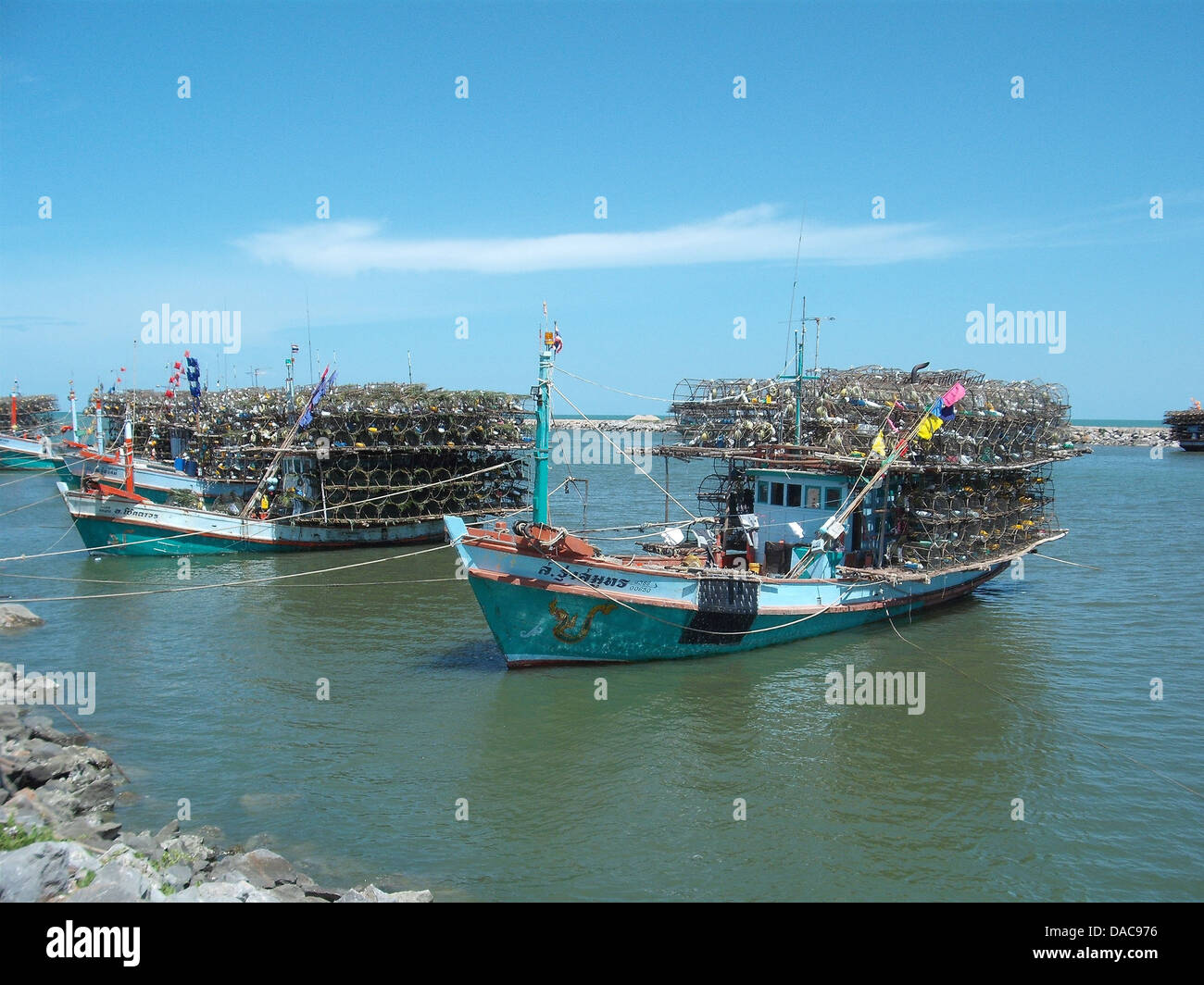 Les bateaux de pêche sont couramment vus au large des côtes thaïlandaises, où les eaux côtières du pays soutiennent une industrie de la pêche florissante. Ces bateaux sont utilisés pour pêcher les fruits de mer, contribuant de manière significative à l’économie thaïlandaise et fournissant des emplois locaux. Banque D'Images