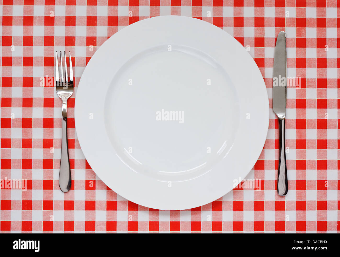 Réglage de la plaque vide avec la plaque, le couteau et la fourchette sur fond vichy rouge symbole populaire pour diners et cafés Banque D'Images