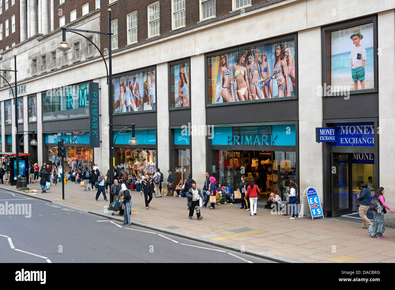 Un trottoir animé avec des acheteurs à l'extérieur de Primark vêtements de mode rapide magasin de détail avant et magasins fenêtres Oxford Street West End Londres Angleterre Royaume-Uni Banque D'Images