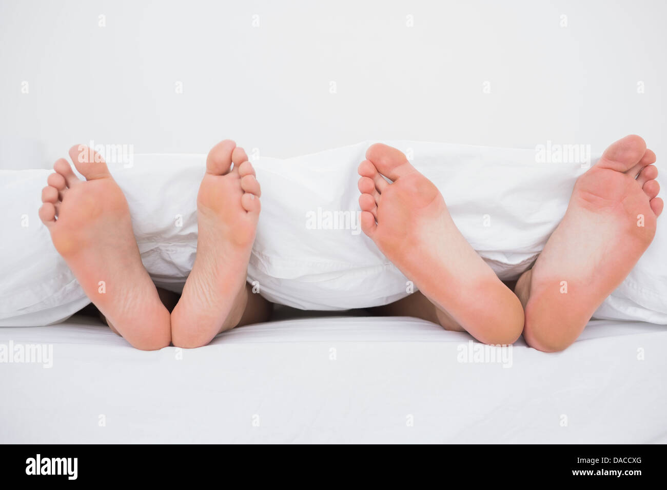 Pieds d'un couple in bed Banque D'Images