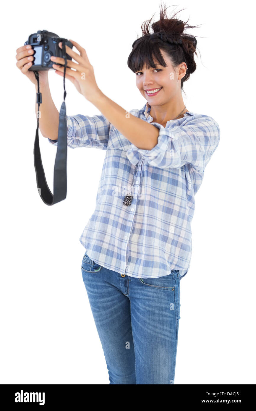Smiling brunette prendre photo avec son appareil photo Banque D'Images