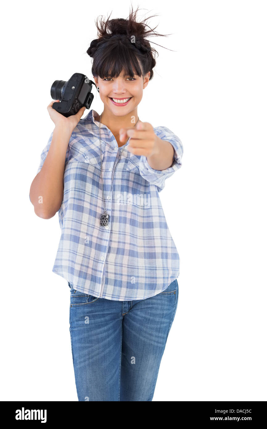Smiling woman holding camera et pointant son doigt Banque D'Images