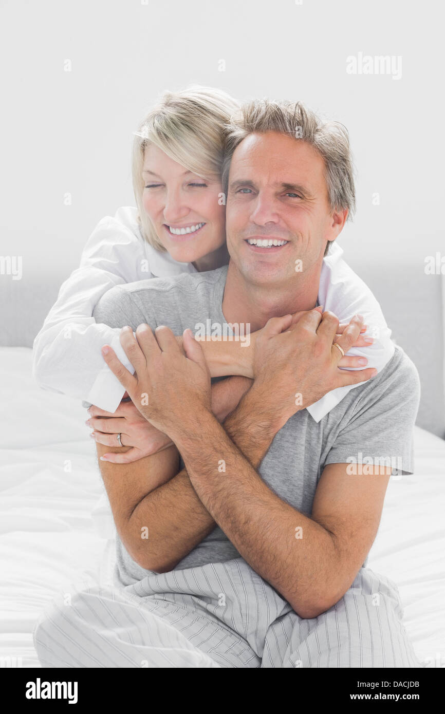 Embracing couple smiling at camera Banque D'Images