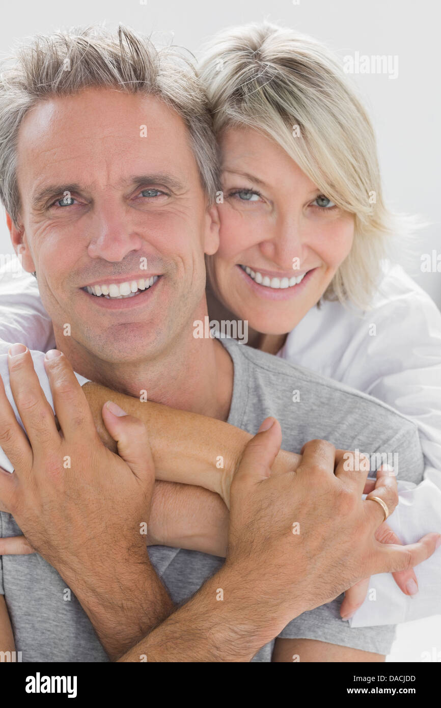 Hugging couple smiling at camera Banque D'Images
