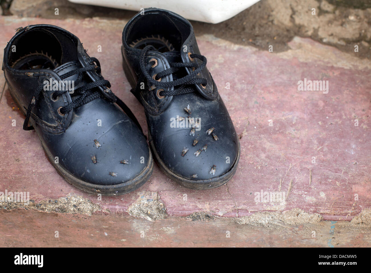 L'Inde les bidonvilles petit enfant chaussures femme avec vole sur sur un mur Banque D'Images