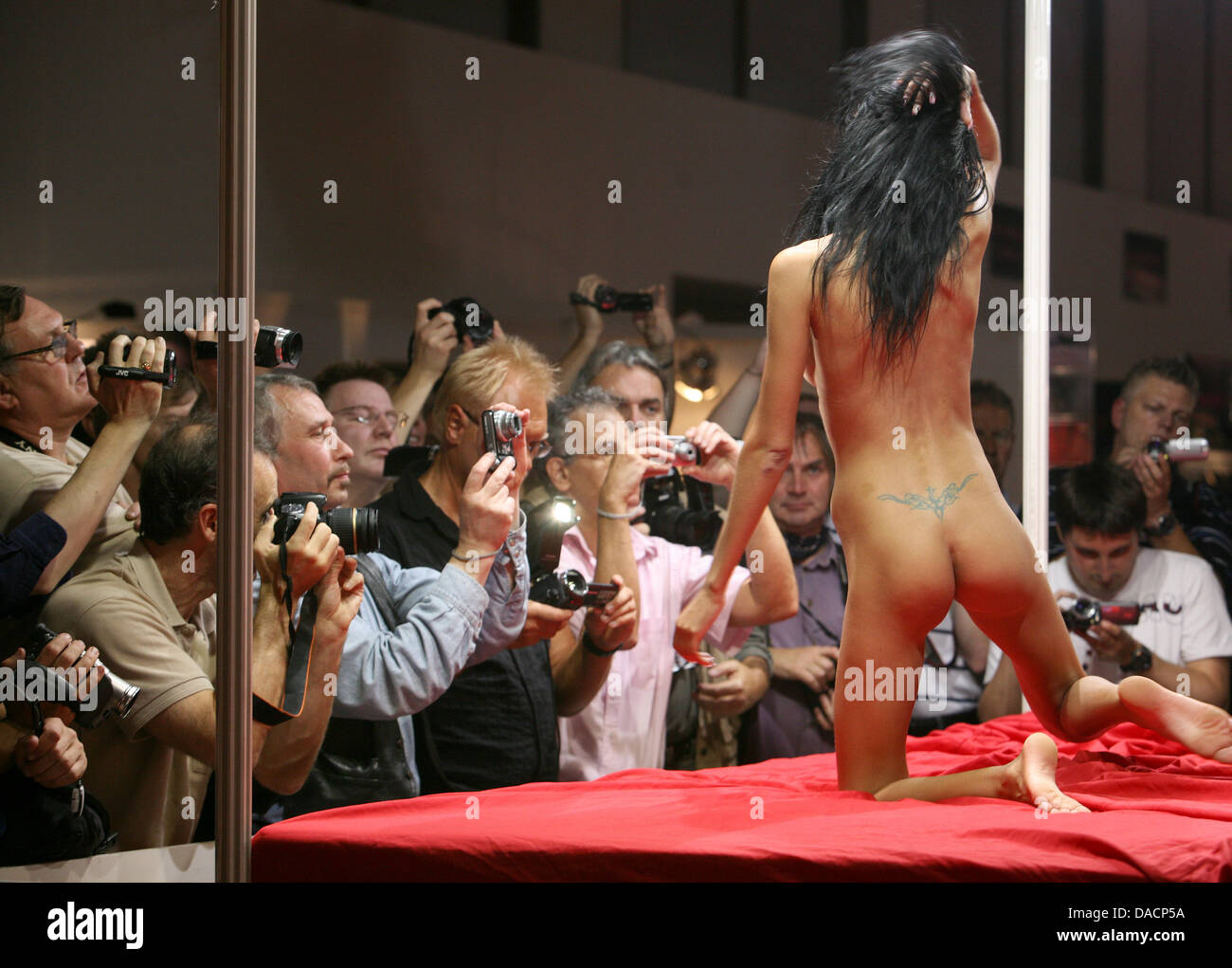 Une femme nue (R) effectue sur une plate-forme rouge comme une foule  d'hommes avec des caméras se rassembler autour d'elle pendant le 2011  érotique Vénus, à Berlin, Allemagne, le 29 septembre 2011.
