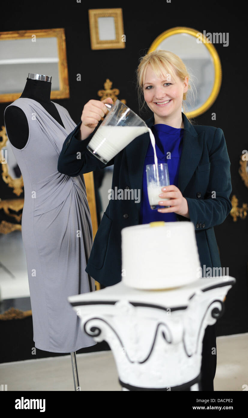 Designer de mode et biochimiste Anke Domaske pose avec une robe, des fibres  de lait et une bouteille de lait à son studio à Hanovre, Allemagne, 19  septembre 2011. Les 29 ans