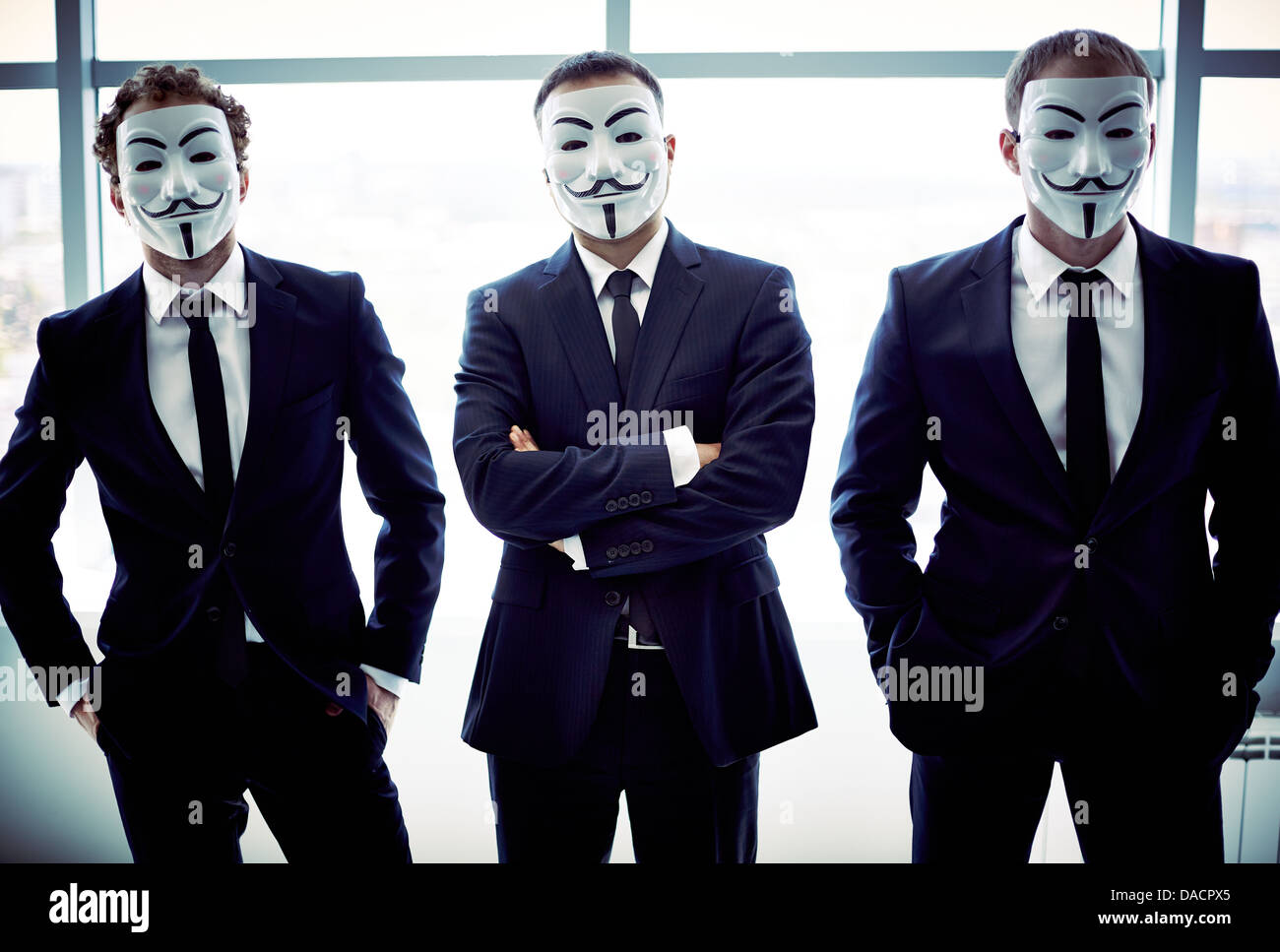 Portrait de trois collègues de se cacher derrière des masques de Guy Fawkes Banque D'Images