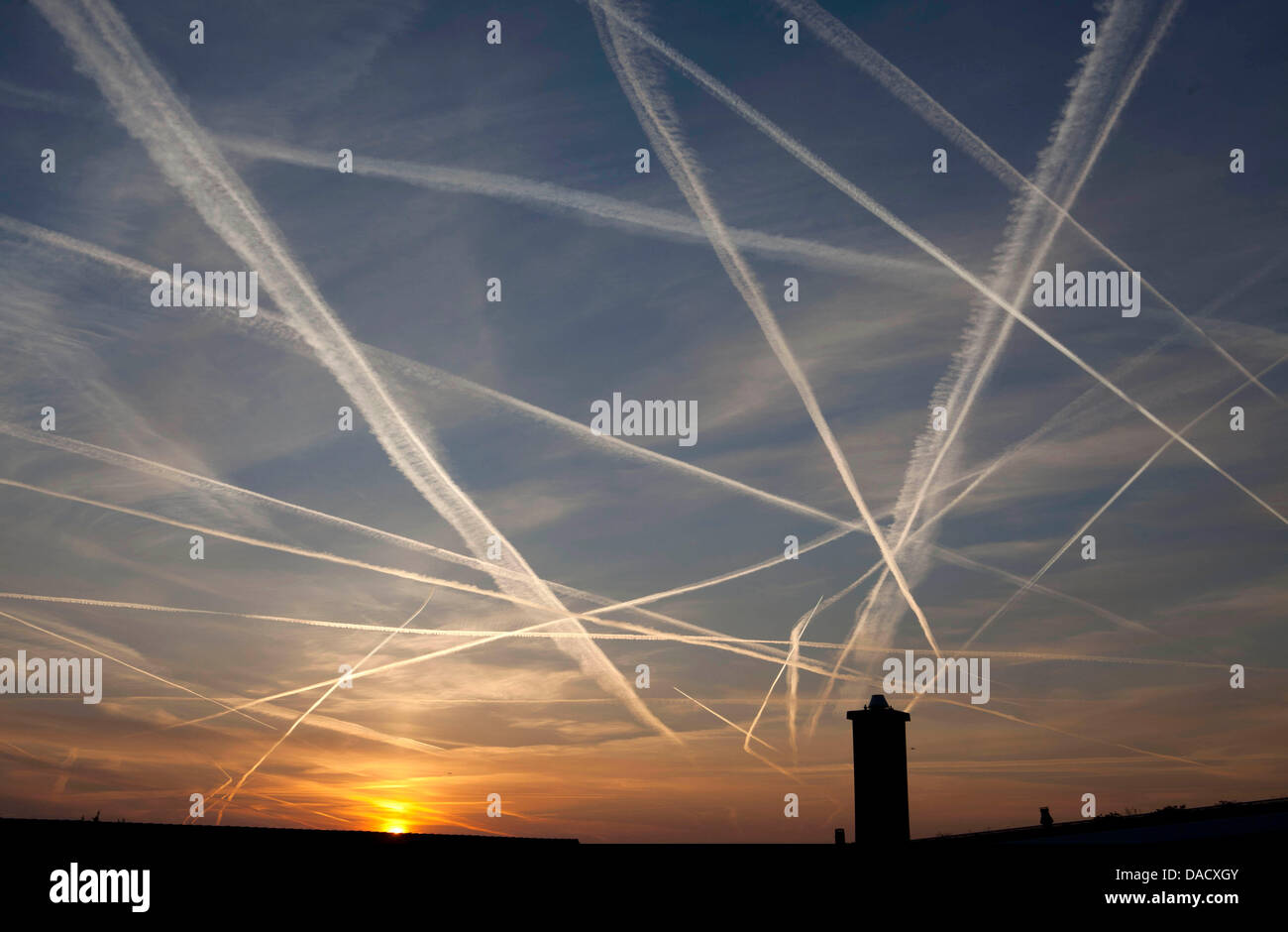 (Dossier) une archive photo datée du 12 mars 2011 montrent de nombreuses traînées causées par les avions dans le ciel au lever du soleil au-dessus de Francfort-sur-Main, Allemagne. La Cour européenne de justice de Luxembourg a décidé de permettre l'inclusion des compagnies aériennes étrangères dans l'échange d'émissions de l'UE Mercredi, 21 décembre 2011. L'échange de droits d'émission exige que les sociétés d'acheter des droits pour l'émission de la serre Banque D'Images