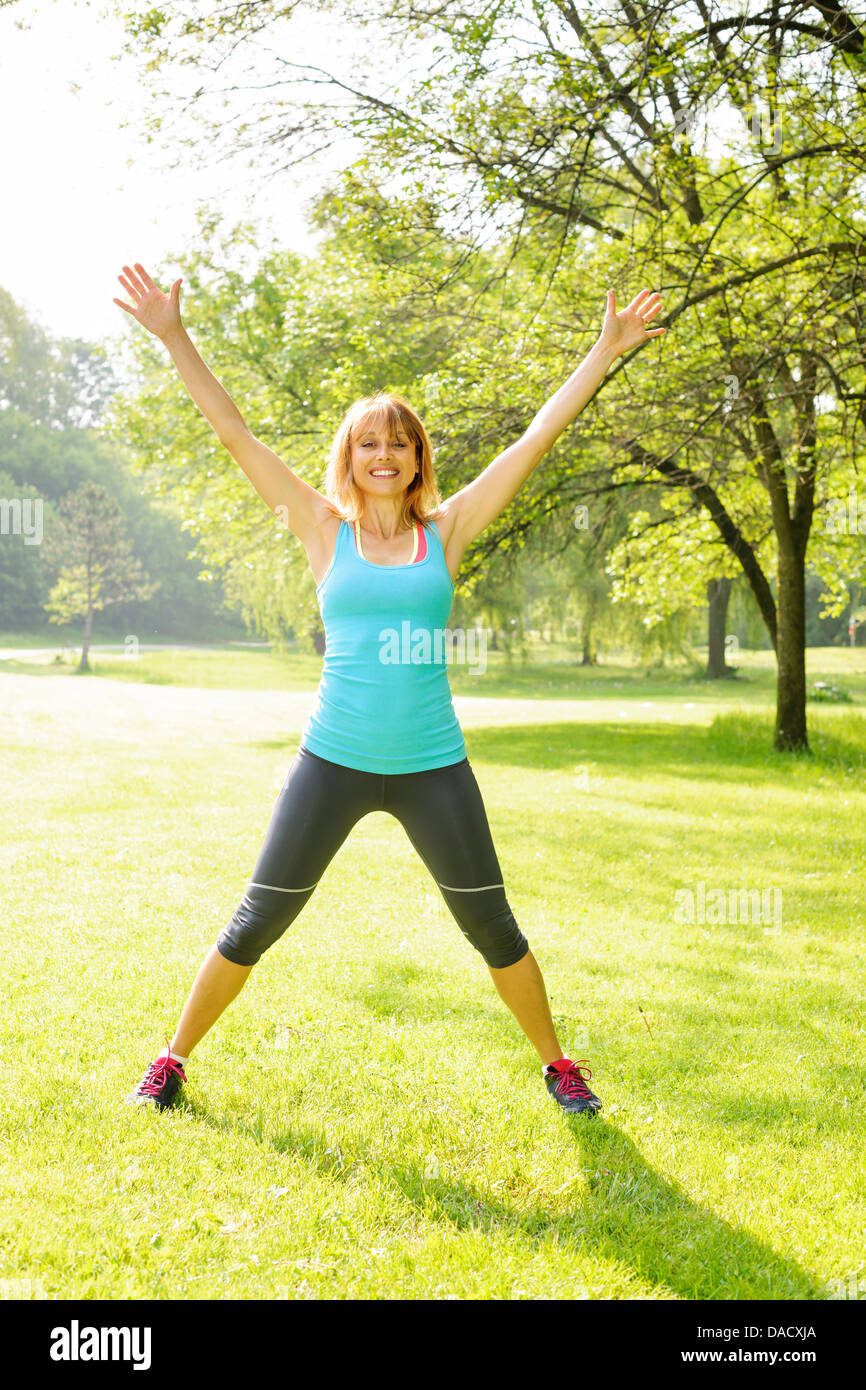 Instructeur de conditionnement physique des femmes faisant l'exercice jumping jacks dans Green Park Banque D'Images