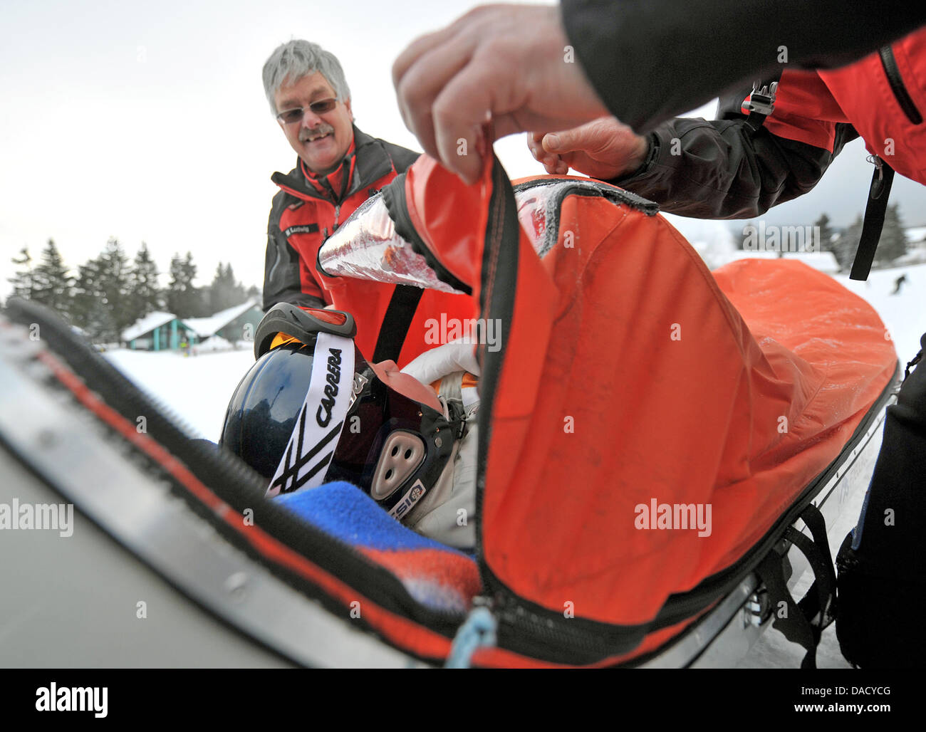 Les membres d'un service de secours en montagne de la Croix-Rouge allemande (DRK) sont illustrés au cours d'un exercice de sauvetage à une pente de ski à Oberwiesenthal, Allemagne, le 19 décembre 2011. Le service de sauvetage en montagne fait face à quelque 550 opérations de sauvetage par saison. Les skieurs et planchistes surtout besoin de l'aide du service. Photo : Hendrik Schmidt Banque D'Images