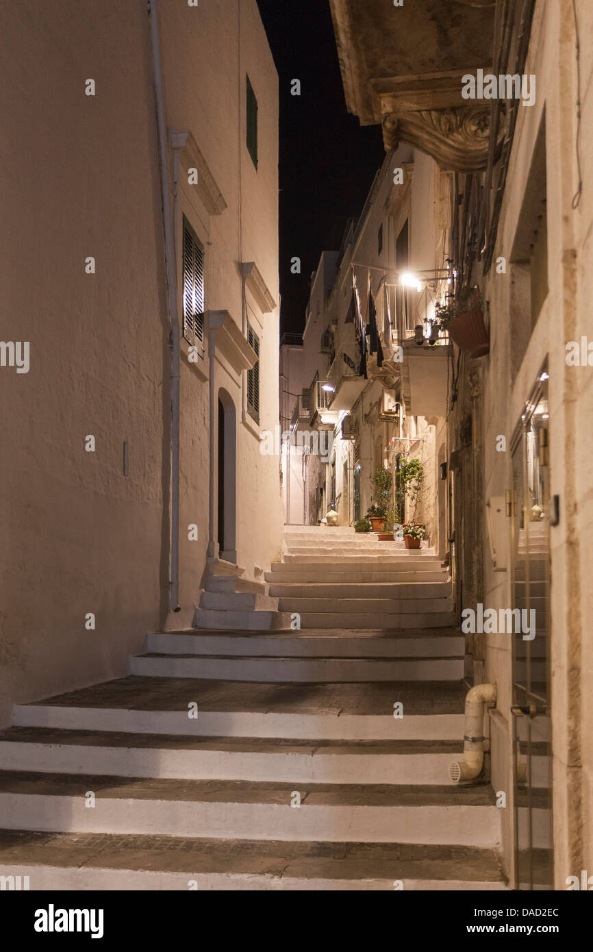 Ruelle et maisons blanchies à la chaux des étapes entre la nuit dans le centre historique d'Ostuni, la ville des Pouilles, Italie du sud Banque D'Images