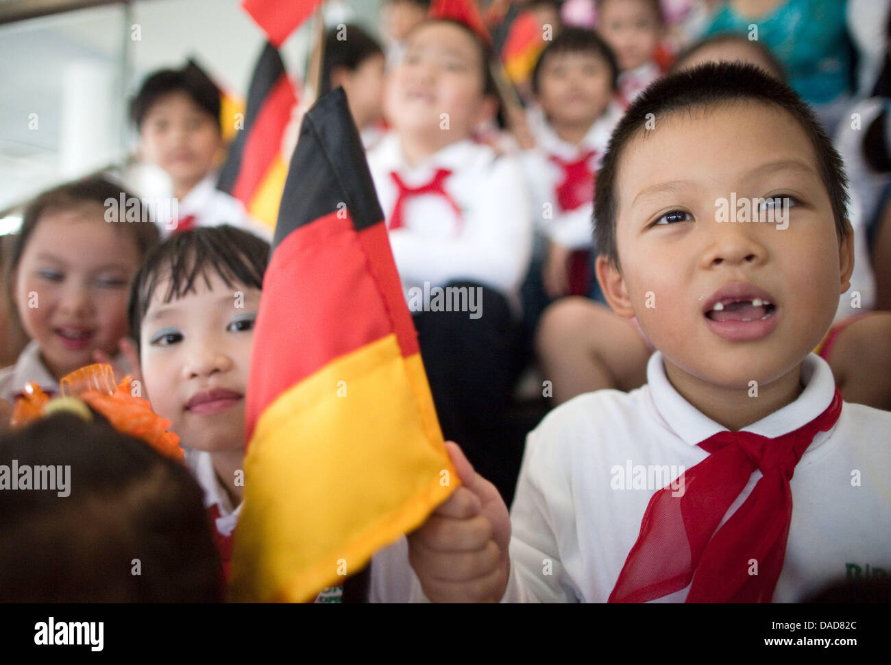 Un garçon vietnamien est titulaire d'un drapeau allemand guide de touriste alors que la Chancelière allemande, Angela Merkel, assiste à l'ouverture d'une usine de la technologie médicale fabricant B.Braun à Hanoi, Vietnam, 11 octobre 2011. Rencontre entre le premier ministre Tan Dzung, Merkel a l'intention de visiter les entreprises économiques lors de sa visite officielle. Photo : MICHAEL KAPPELER Banque D'Images