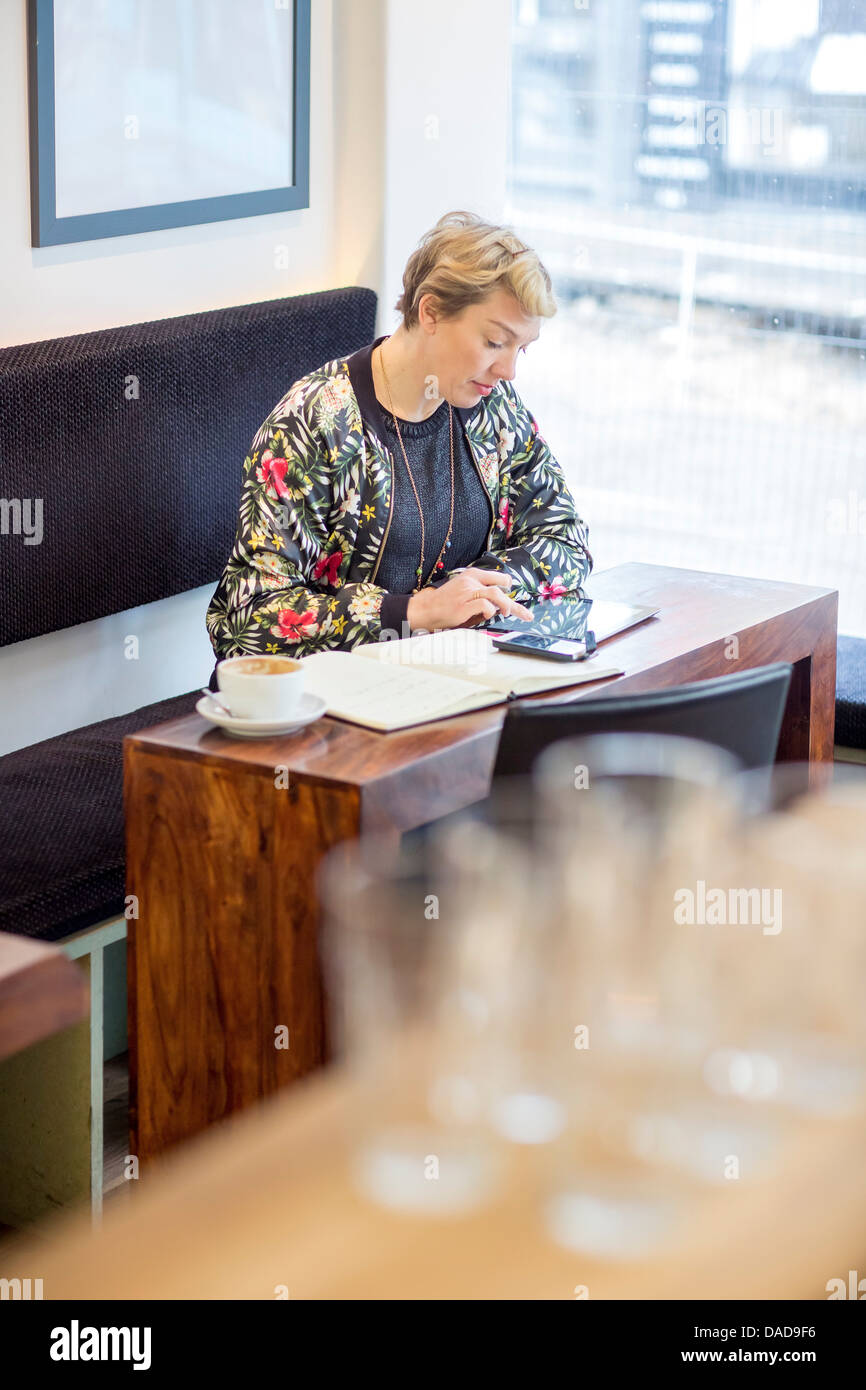 Woman using digital tablet in cafe Banque D'Images