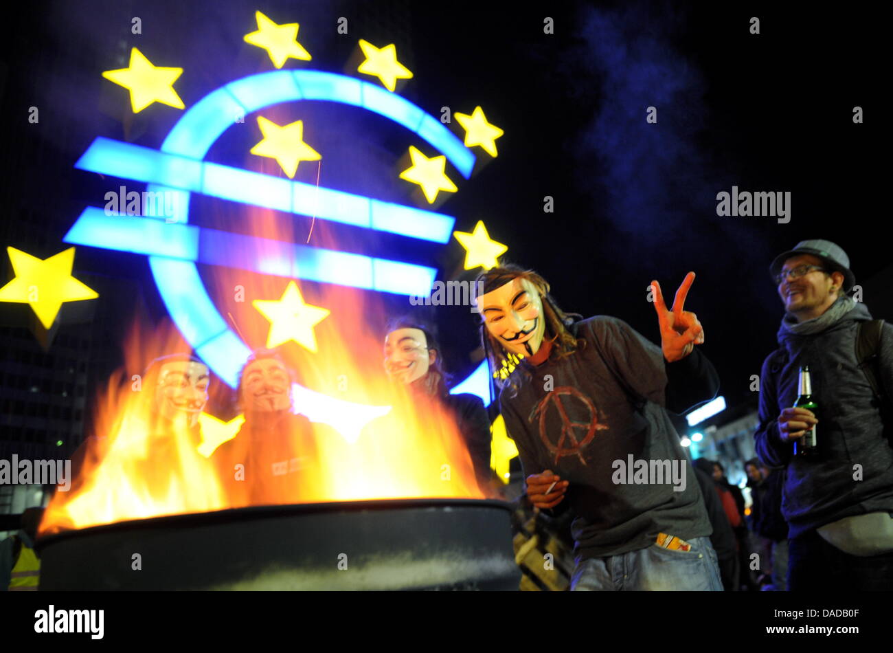 Les manifestants portant des masques de Guy Fawkes' 'debout à côté d'un feu en face de la Banque centrale européenne à Francfort-sur-Main, Allemagne, 15 octobre 2011. Plusieurs milliers de personnes ont manifesté contre le pouvoir des marchés financiers. Le mouvement lui-même des modèles sur l'American 'Occupy Wall Street' manifestations. Photo : Arne Dedert Banque D'Images