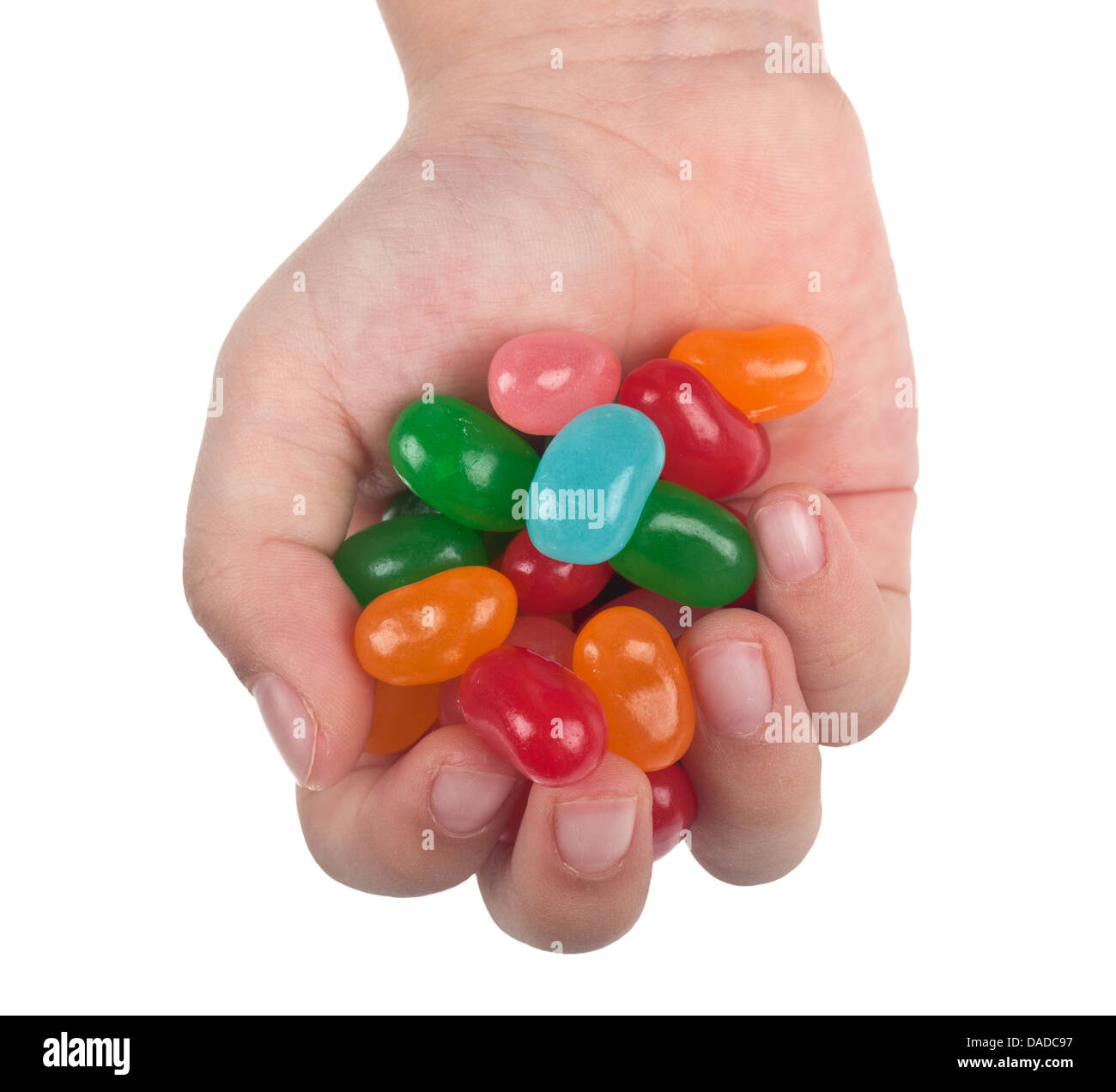 La main de l'enfant pleine de jelly bean candy isolé sur fond blanc Banque D'Images