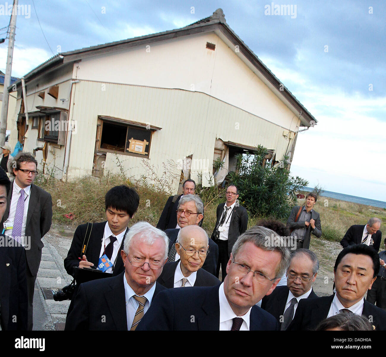 Le Président allemand Christian Wulff (C) des visites de la ville côtière de Toyoma vues et les dommages causés par la catastrophe du tsunami dans la préfecture de Fukushima, au Japon, 25 octobre 2011. Le chef de l'état allemand est au Japon pour une visite d'Etat de six jours. Photo : WOLFGANG KUMM Banque D'Images