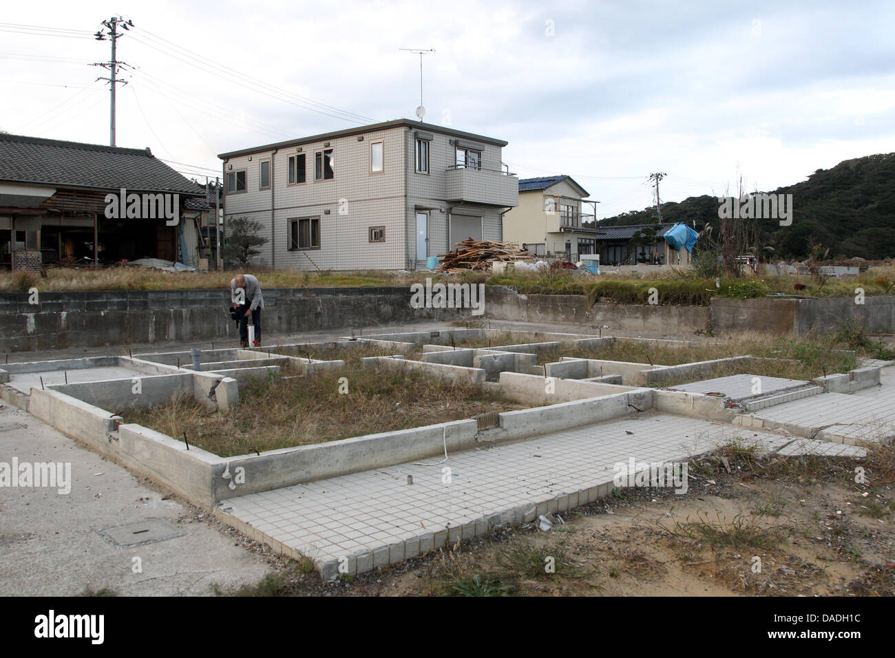 Membre de la délégation de l'Président allemand Christian Wulff films les dommages causés par le tsunami dans la ville côtière de Toyoma, dans la préfecture de Fukushima, au Japon, 25 octobre 2011. Le chef de l'état allemand est au Japon pour une visite d'Etat de six jours. Photo : WOLFGANG KUMM Banque D'Images
