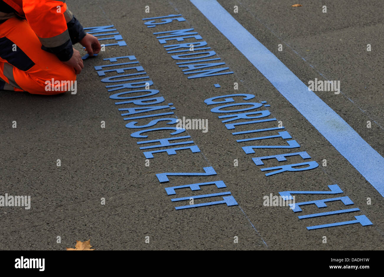 Jan Seifert marque le cours de la 15e méridien à Görlitz, Allemagne, 25 octobre 2011. La frontière germano-polonaise ville est la seule ville d'allemagne située sur la 15e ligne de longitude. Le méridien est l'axe central de l'Europe centrale, actuellement indiqué par la ligne bleue sur le béton. Photo : MATTHIAS HIEKEL Banque D'Images