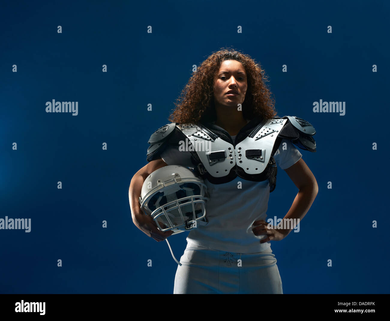 Portrait de femme joueur de football américain avec les épaulettes et le casque Banque D'Images
