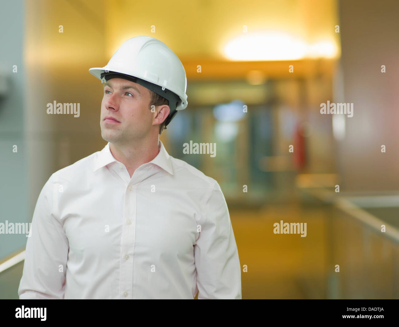 Young construction worker in hard hat, looking up Banque D'Images