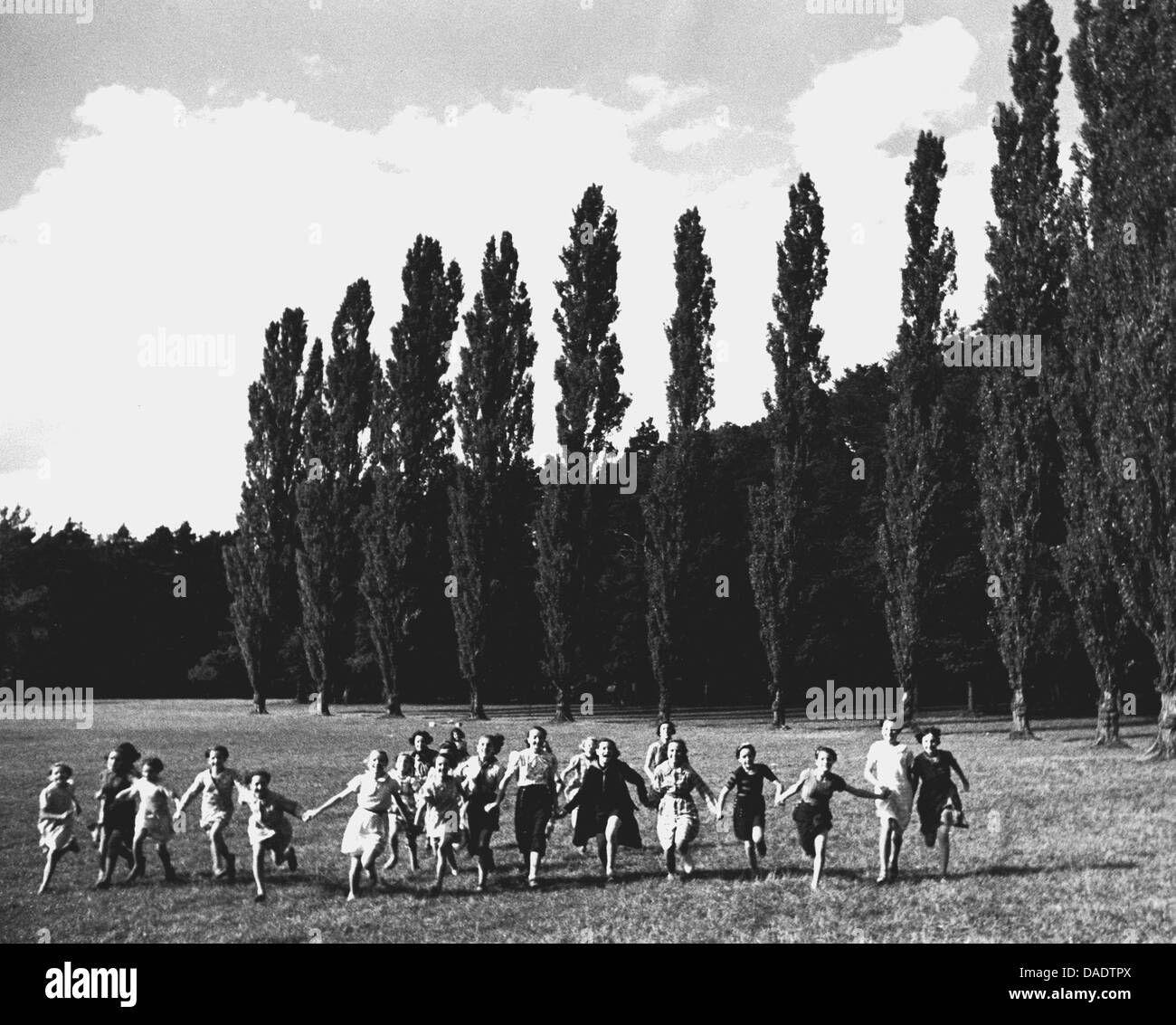 1938, les enfants et les adultes courir sur pré. Image by photographe Fred Stein (1909-1967) qui a émigré à partir de 1933 l'Allemagne nazie pour la France et enfin aux États-Unis. Banque D'Images