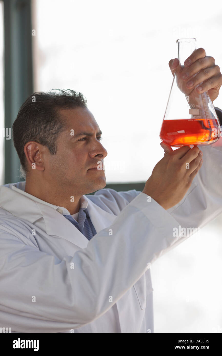 Mature scientist looking at liquid fiole en Banque D'Images